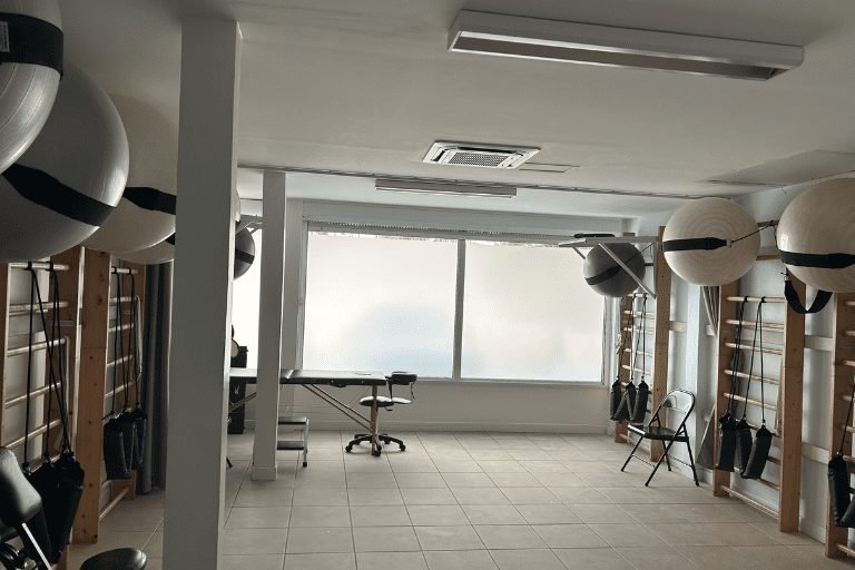 Spacieux gymnase de rééducation lumineux équipé d'espaliers muraux et de ballons de gym